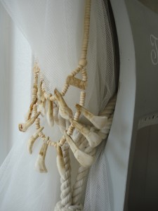 bone necklaces and tassels on muslin curtains